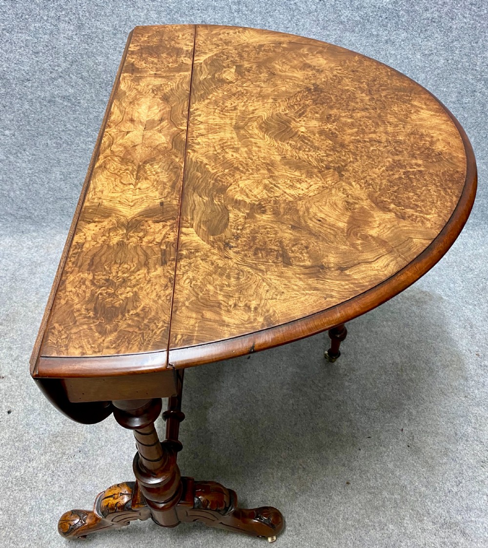 A Victorian burr walnut drop-leaf table featuring symmetrical figured grain, turned supports, spiral stretchers, and carved legs on castors. View VII