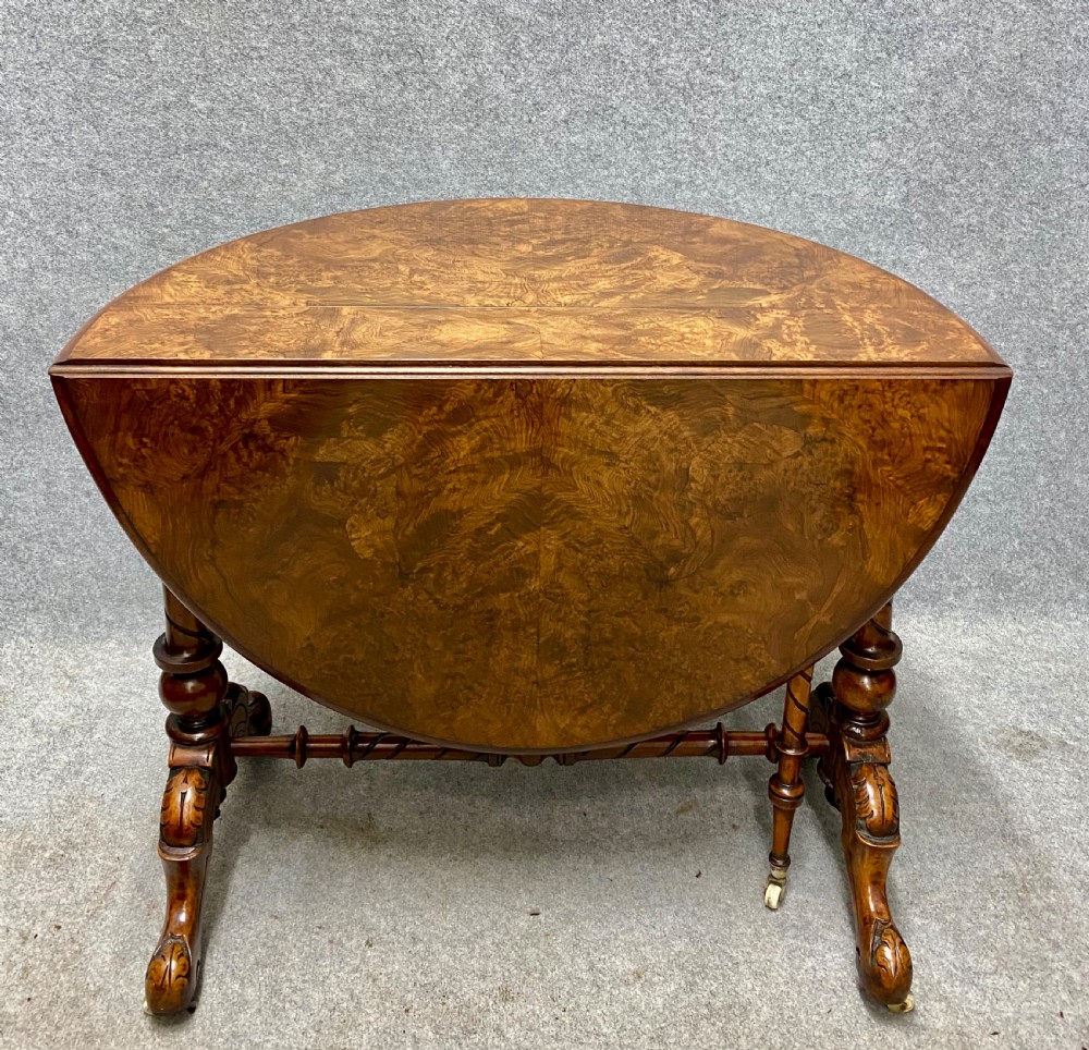 A Victorian burr walnut drop-leaf table featuring symmetrical figured grain, turned supports, spiral stretchers, and carved legs on castors. View VIII