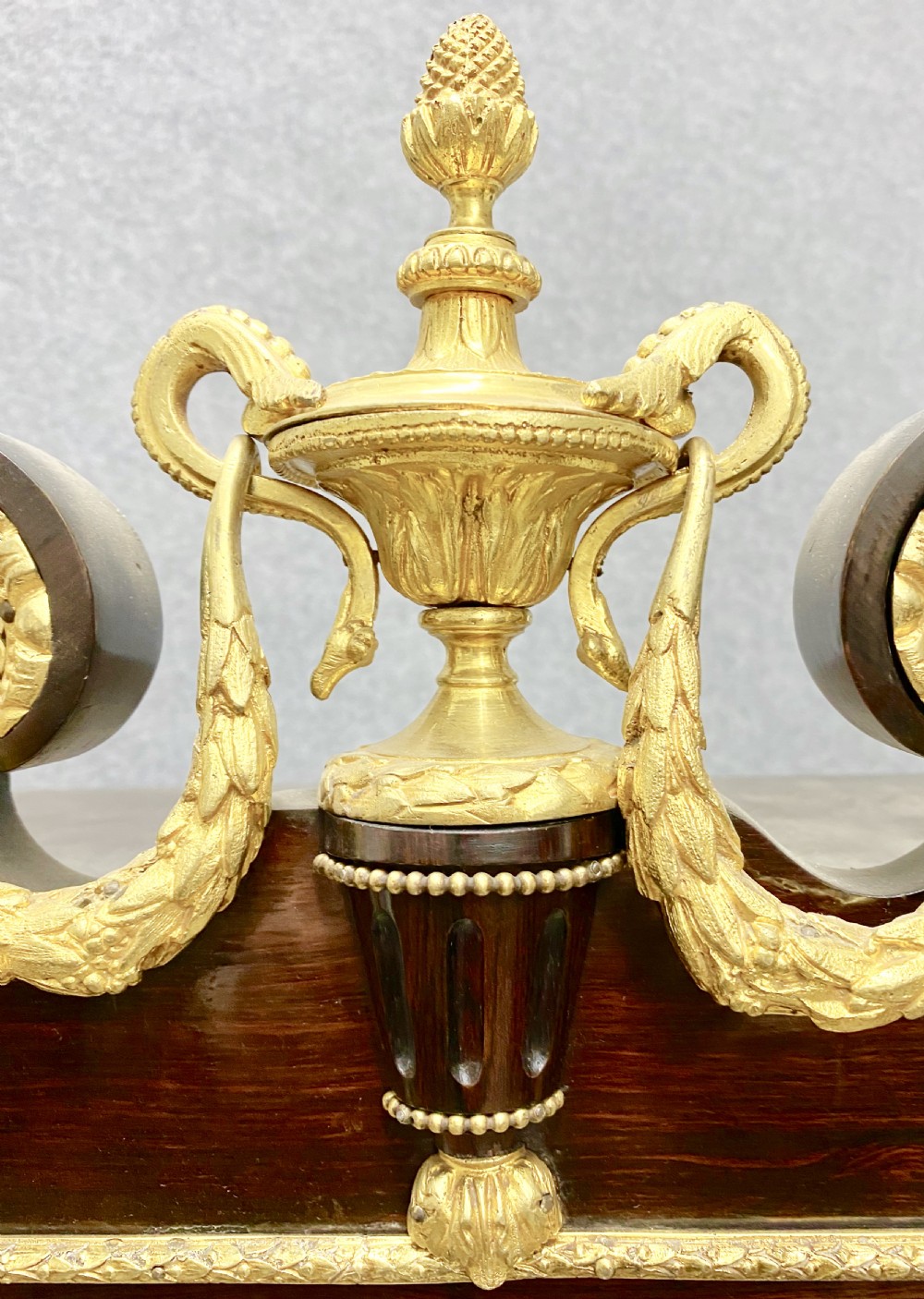 A two-tier dark mahogany display cabinet featuring gilt bronze mounts, glazed panels, fluted columns, and finial decorations. View III