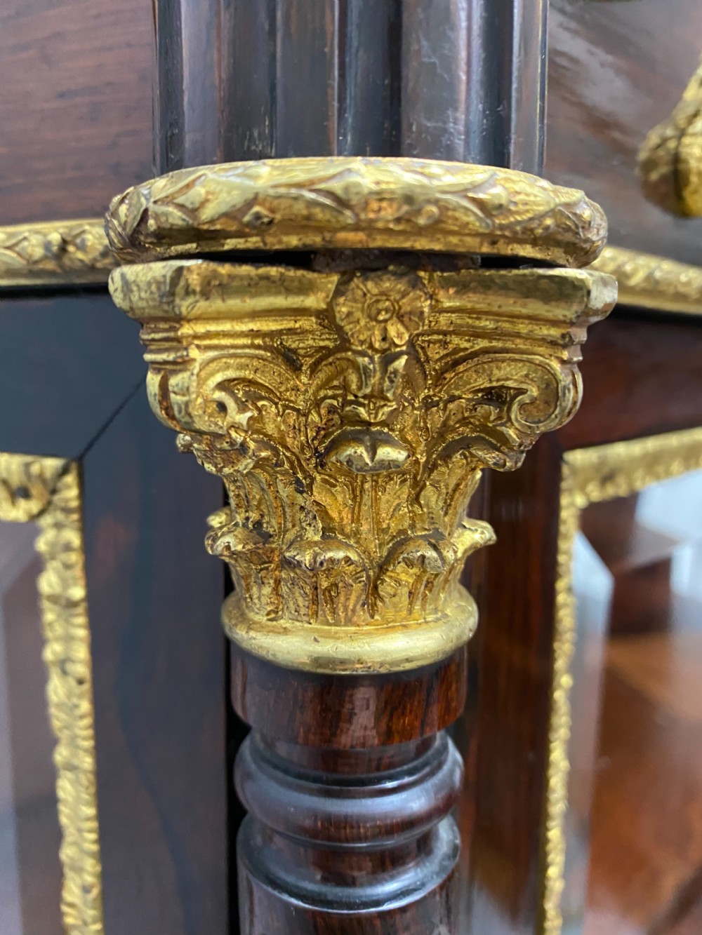 A two-tier dark mahogany display cabinet featuring gilt bronze mounts, glazed panels, fluted columns, and finial decorations. View VIII
