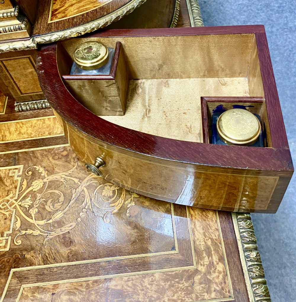 A Louis XVI Revival bonheur du jour writing desk with intricate floral marquetry inlay, a central cabinet door, gilt-bronze mounts, and fluted tapered legs. View V