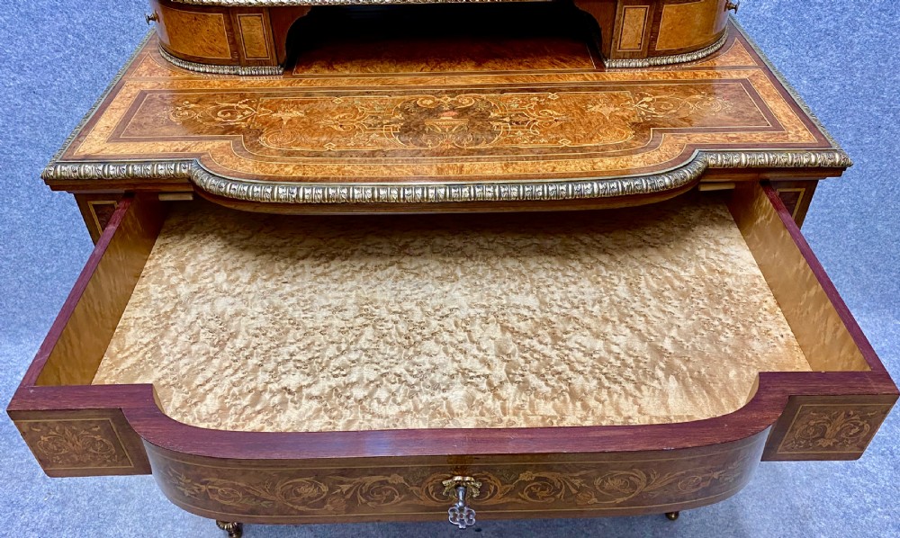 A Louis XVI Revival bonheur du jour writing desk with intricate floral marquetry inlay, a central cabinet door, gilt-bronze mounts, and fluted tapered legs. View XII