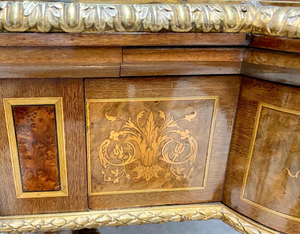 A Louis XVI Revival bonheur du jour writing desk with intricate floral marquetry inlay, a central cabinet door, gilt-bronze mounts, and fluted tapered legs. View XIV