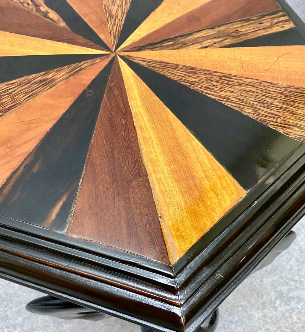 An hexagonal antique side table featuring a radiating starburst specimen wood top supported by hand-carved ebony elephant legs. View VI