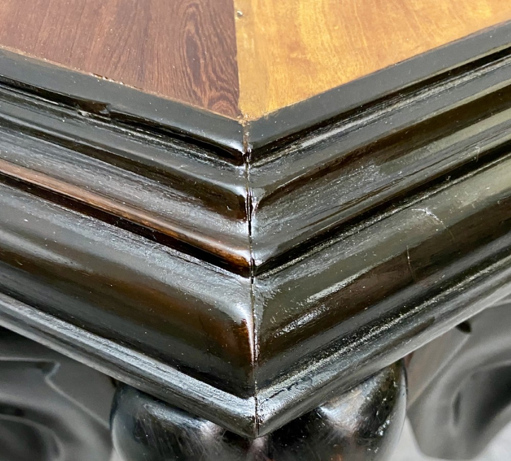 An hexagonal antique side table featuring a radiating starburst specimen wood top supported by hand-carved ebony elephant legs. View X