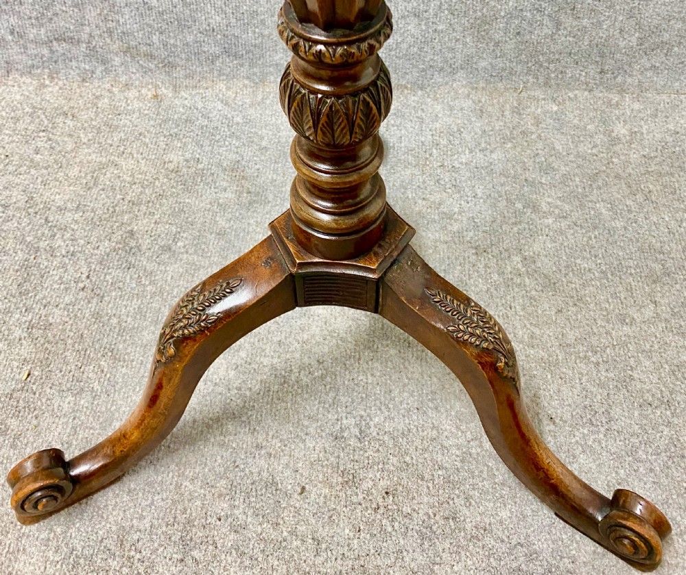 A wooden Hepplewhite style wine table featuring a scalloped top, a fluted central pedestal stem, and three carved tripod legs. View V