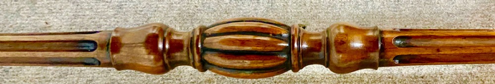 A Victorian burr walnut Sutherland table shown with its drop leaves closed, displaying swirling wood grain veneers, carved legs, and brass castors. View VIII