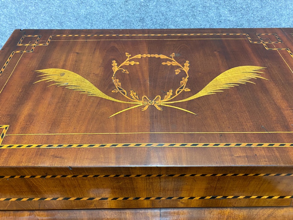 A Dutch marquetry cylinder bureau crafted from warm brown wood with trompe loeil writing tool inlays, fitted drawers, brass handles, and a curved bombe base. View XI