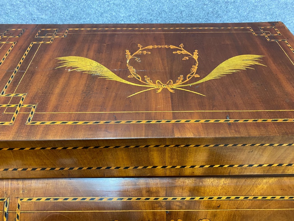 A Dutch marquetry cylinder bureau crafted from warm brown wood with trompe loeil writing tool inlays, fitted drawers, brass handles, and a curved bombe base. View XII