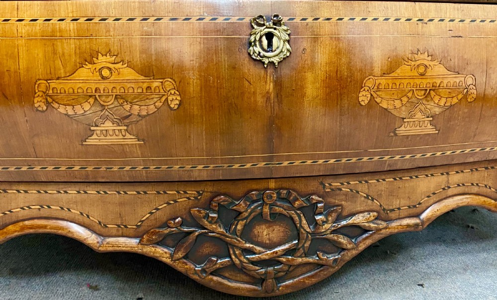 A Dutch marquetry cylinder bureau crafted from warm brown wood with trompe loeil writing tool inlays, fitted drawers, brass handles, and a curved bombe base. View XIV