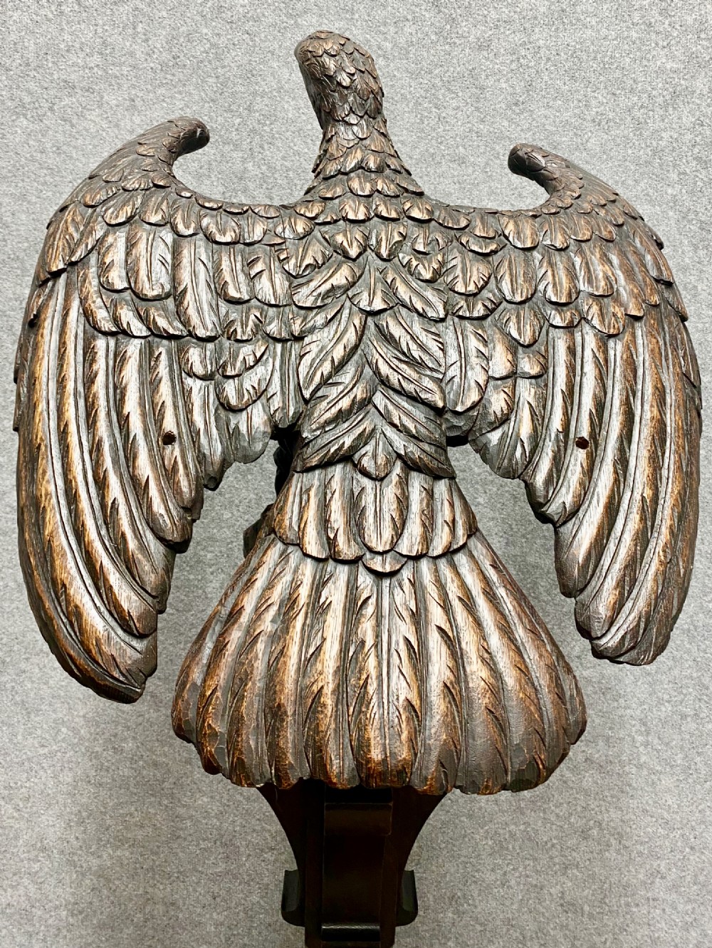 A dark carved oak eagle lectern featuring a sculpture of an eagle with wings spread mounted on an architectural pedestal stand. View IV