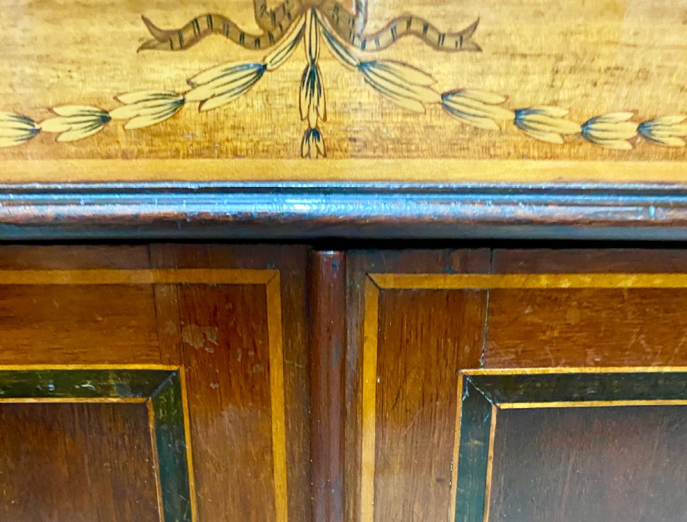 A tall mahogany and satinwood inlaid corner cabinet featuring a broken swan-neck pediment, upper astragal glazed double doors, and lower panelled cupboard doors. View VII