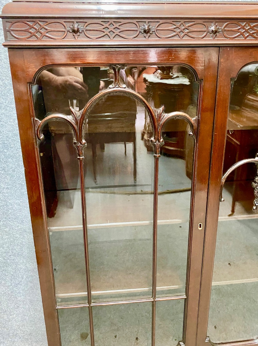 An Edwardian dark mahogany bookcase featuring three glazed doors with astragal tracery, elevated on carved cabriole legs with claw and ball feet. View II