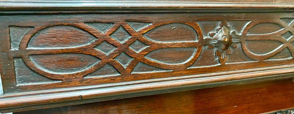 An Edwardian dark mahogany bookcase featuring three glazed doors with astragal tracery, elevated on carved cabriole legs with claw and ball feet. View III