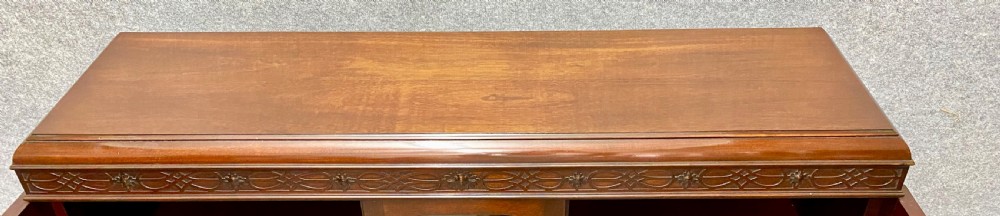 An Edwardian dark mahogany bookcase featuring three glazed doors with astragal tracery, elevated on carved cabriole legs with claw and ball feet. View VI