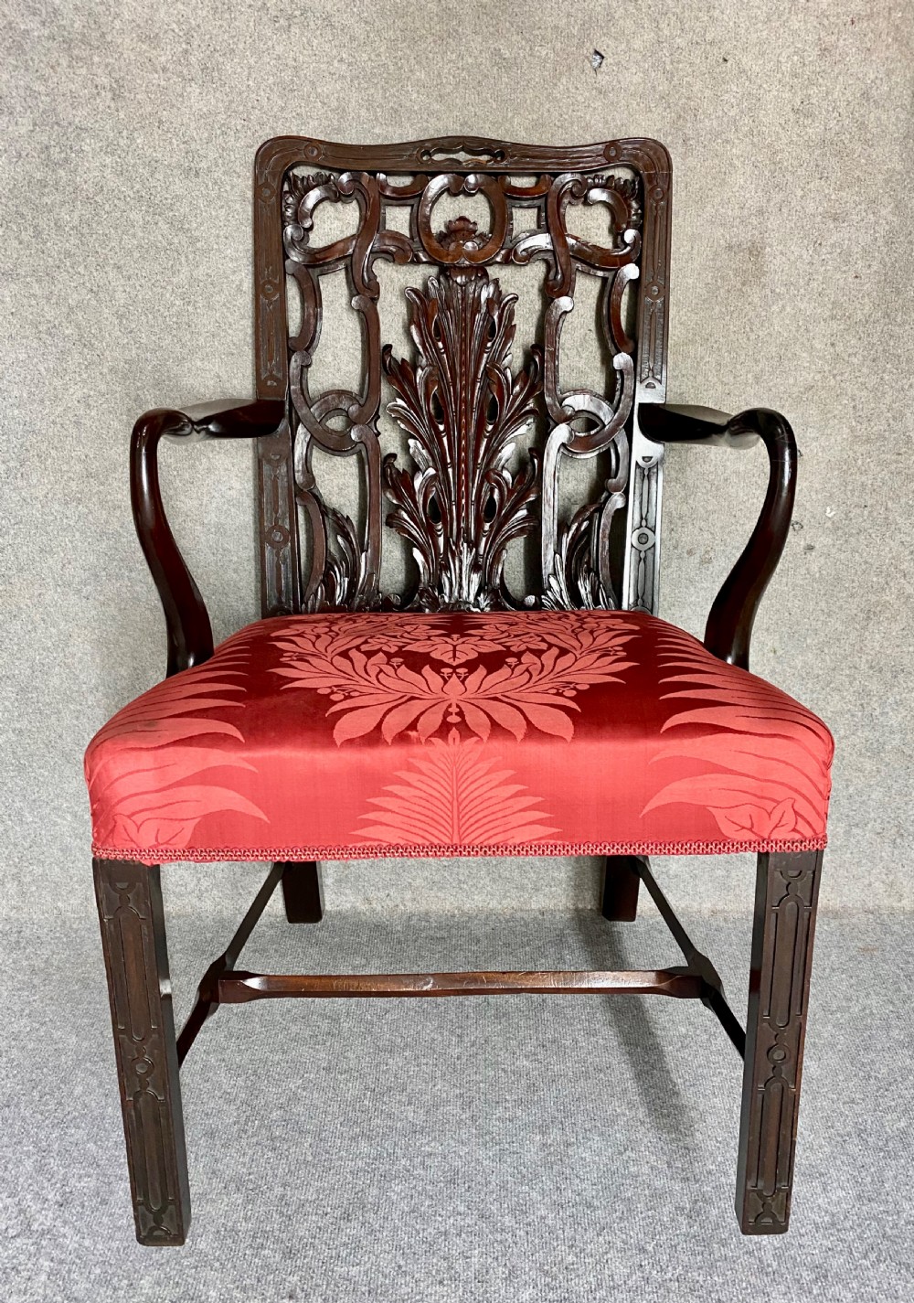 An 18th-century Georgian mahogany elbow chair featuring a detailed pierced splat back, blind fretwork on the front legs, and red patterned damask upholstery. View III
