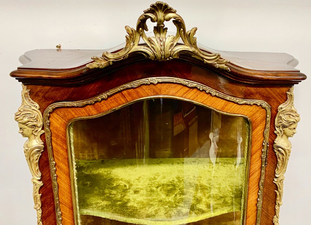 An antique French Louis XV style vitrine featuring serpentine glass sides, ornate gilt bronze mounts, and a lower painted Vernis Martin panel on cabriole legs. View V