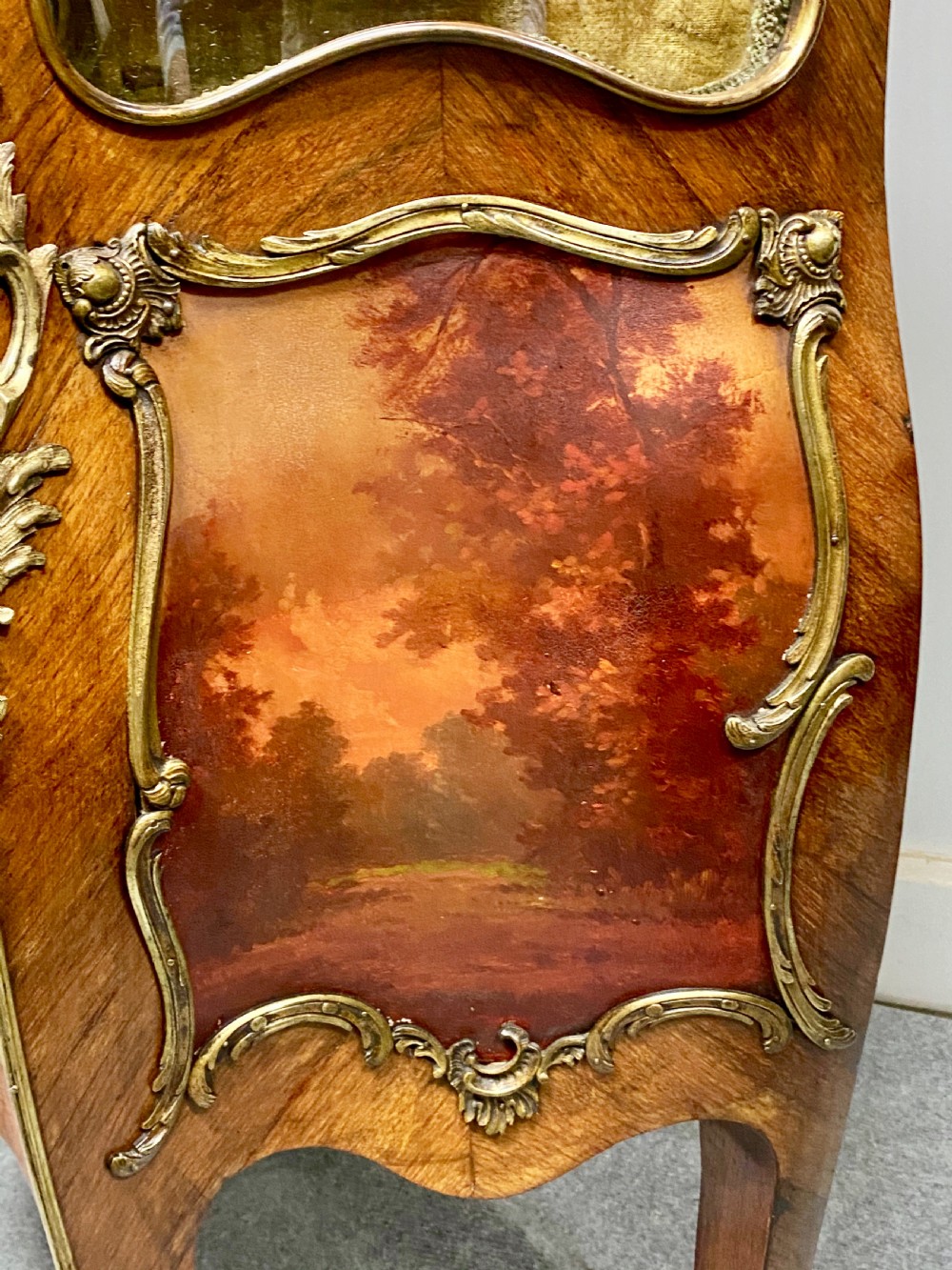 An antique French Louis XV style vitrine featuring serpentine glass sides, ornate gilt bronze mounts, and a lower painted Vernis Martin panel on cabriole legs. View VIII