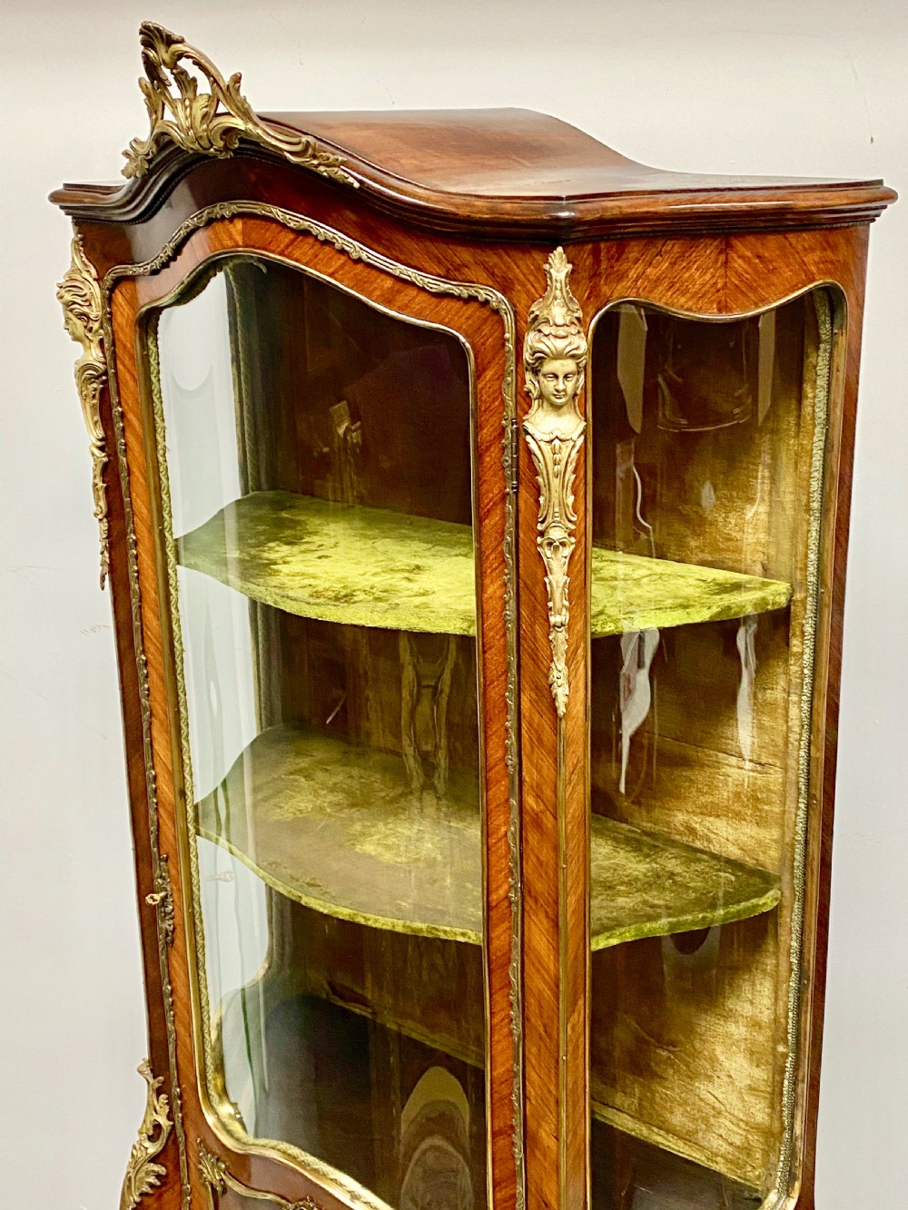 An antique French Louis XV style vitrine featuring serpentine glass sides, ornate gilt bronze mounts, and a lower painted Vernis Martin panel on cabriole legs. View XV