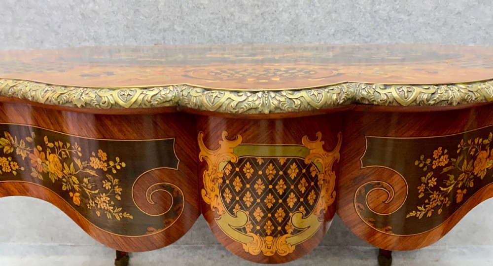 A French Louis XV style centre table featuring intricate floral marquetry inlay, a serpentine contoured top, cabriole legs, and bronze espagnolette mounts. View VI