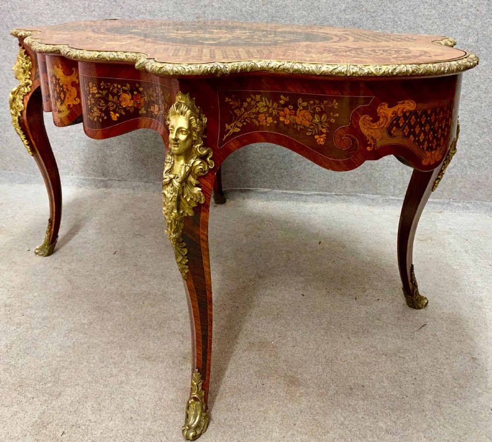 A French Louis XV style centre table featuring intricate floral marquetry inlay, a serpentine contoured top, cabriole legs, and bronze espagnolette mounts. View VIII
