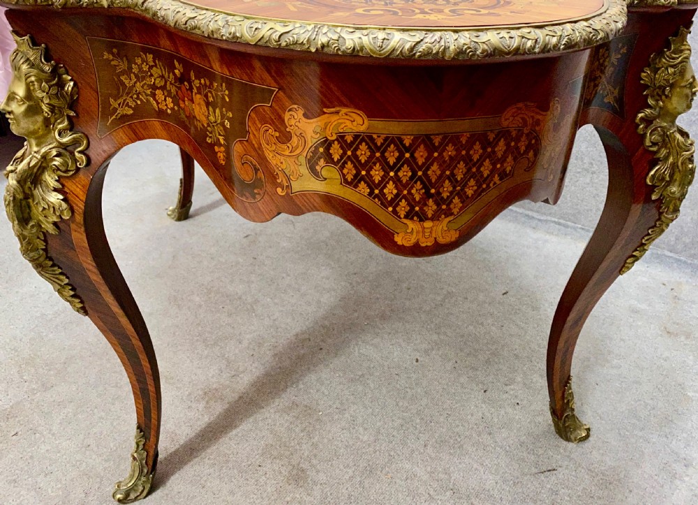 A French Louis XV style centre table featuring intricate floral marquetry inlay, a serpentine contoured top, cabriole legs, and bronze espagnolette mounts. View X