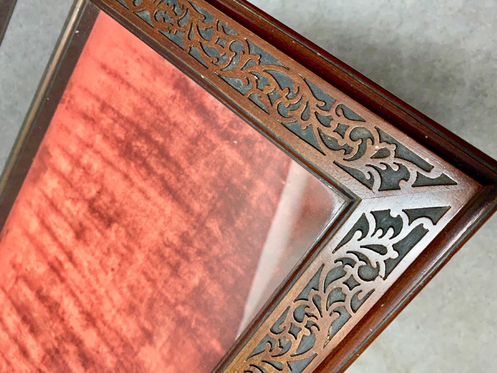 An antique glazed mahogany bijouterie table with a red fabric-lined display cavity, pierced fretwork corner brackets, and a lower shelf. View II