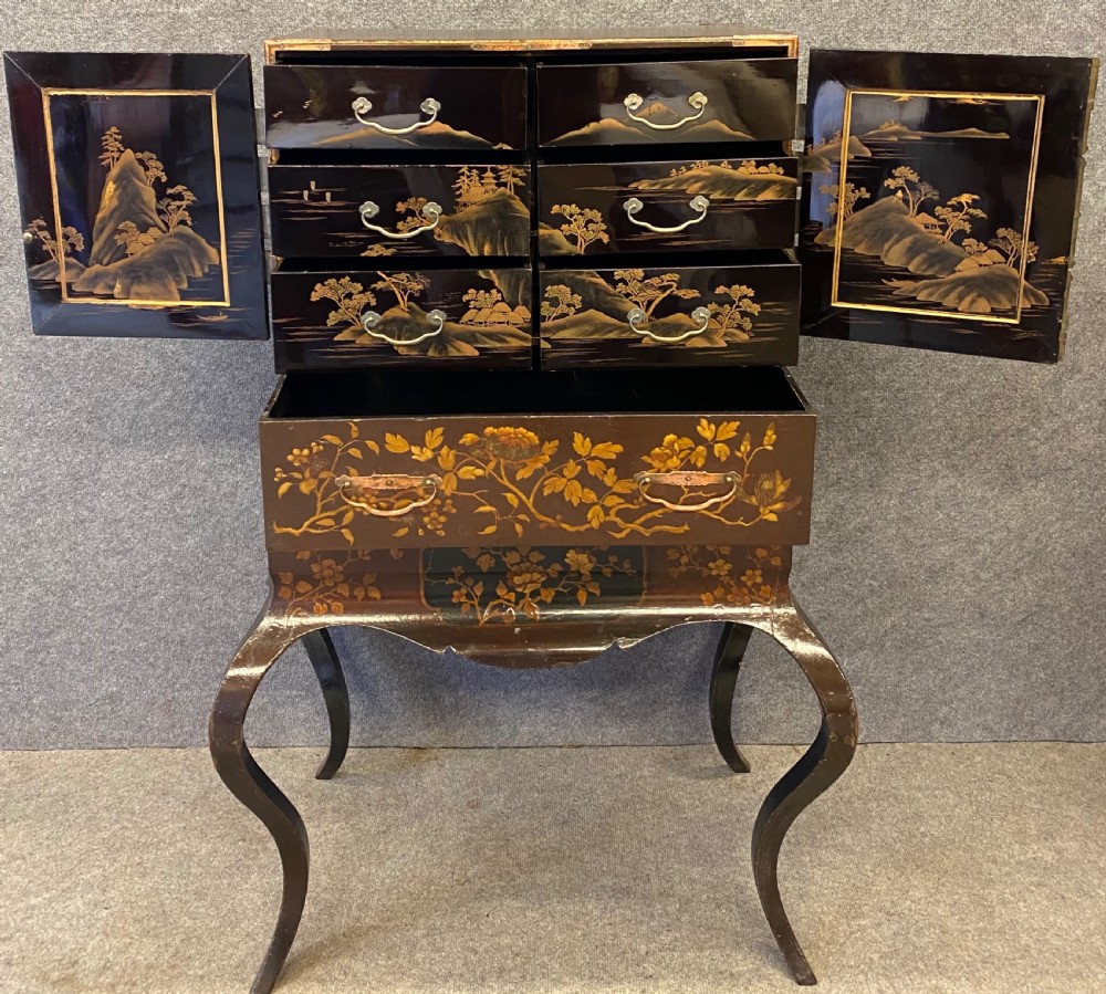 An antique Japanese Meiji period dark lacquer cabinet on a stand, decorated with gold floral and bird motifs and engraved metal mounts. View III