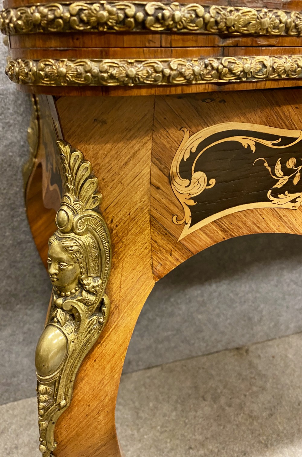 A Louis XV style serpentine card table featuring floral marquetry inlay, kingwood veneer, cabriole legs, and ornate gilt-bronze mounts. View III