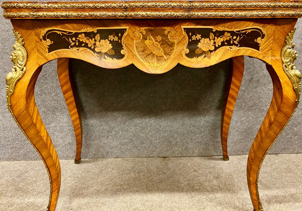 A Louis XV style serpentine card table featuring floral marquetry inlay, kingwood veneer, cabriole legs, and ornate gilt-bronze mounts. View IV