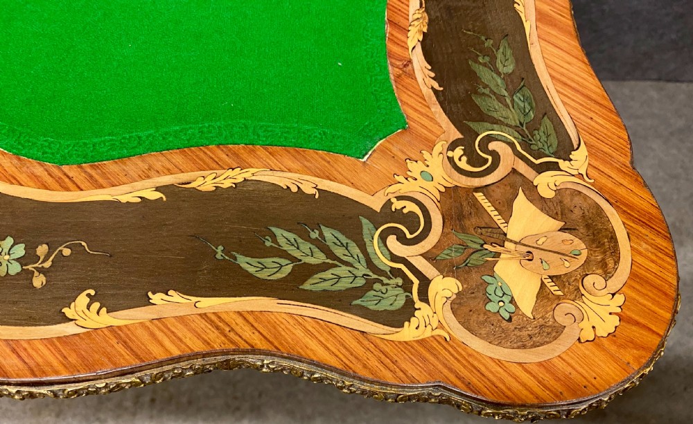 A Louis XV style serpentine card table featuring floral marquetry inlay, kingwood veneer, cabriole legs, and ornate gilt-bronze mounts. View XIII