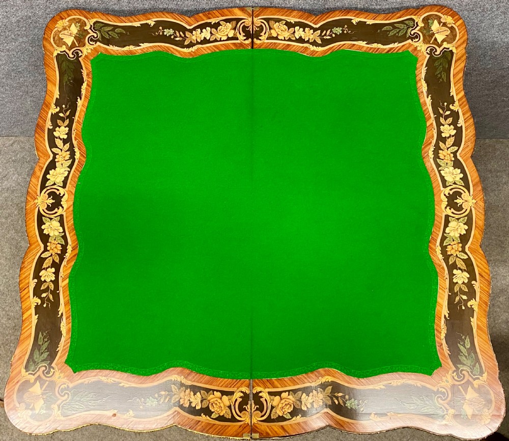 A Louis XV style serpentine card table featuring floral marquetry inlay, kingwood veneer, cabriole legs, and ornate gilt-bronze mounts. View XIV