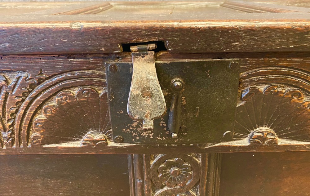 A small seventeenth-century style dark oak coffer featuring a carved lunette frieze, central rosette muntin, and an iron lock plate. View III