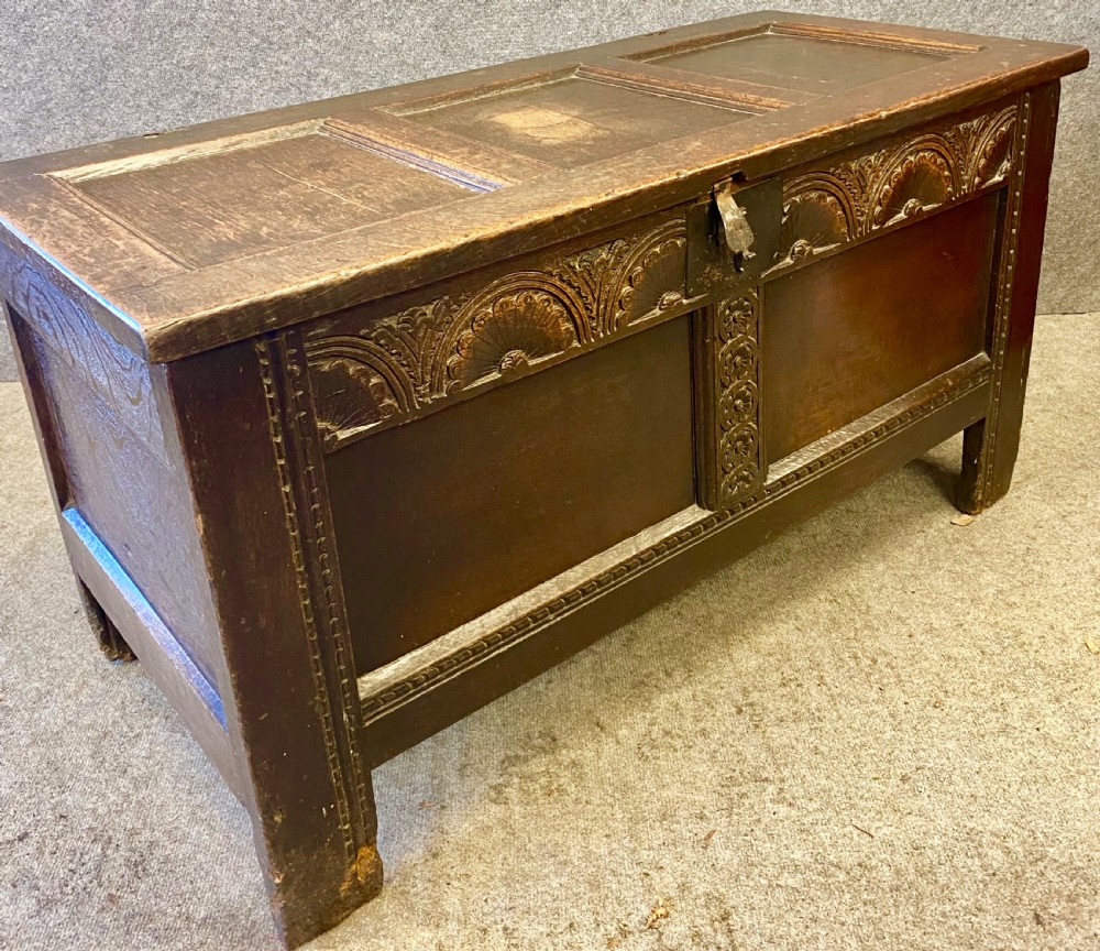 A small seventeenth-century style dark oak coffer featuring a carved lunette frieze, central rosette muntin, and an iron lock plate. View IV