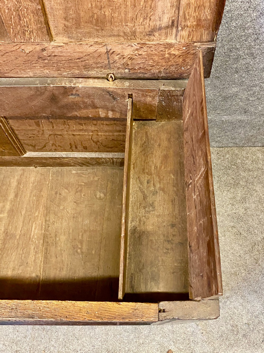A small seventeenth-century style dark oak coffer featuring a carved lunette frieze, central rosette muntin, and an iron lock plate. View VIII
