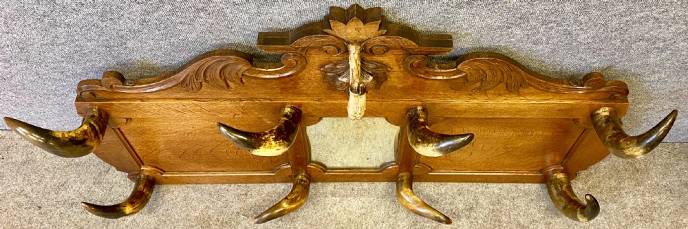 A nineteenth-century wall-mounted carved oak hall stand featuring eight horn hooks, a small central mirror, and scrollwork carving. View III