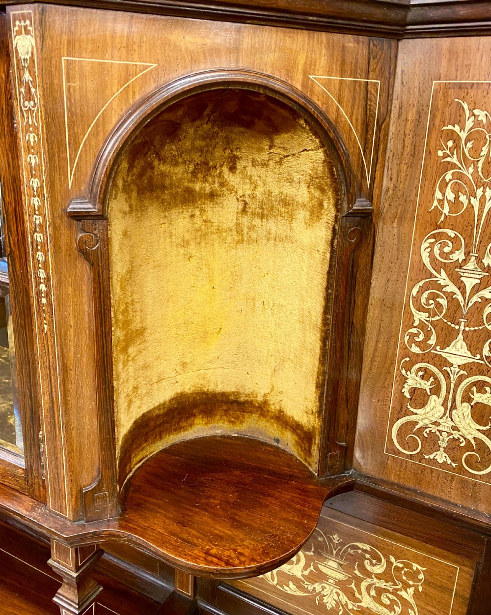 An Aesthetic Movement dark wood side cabinet featuring detailed marquetry inlays, an elevated superstructure with a central glazed cabinet, open niches, a mirror, a single drawer, and lower shelf spaces. View V