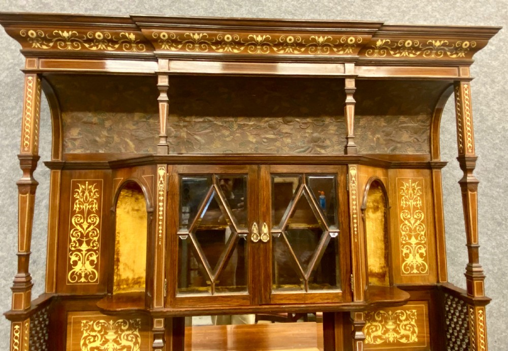 An Aesthetic Movement dark wood side cabinet featuring detailed marquetry inlays, an elevated superstructure with a central glazed cabinet, open niches, a mirror, a single drawer, and lower shelf spaces. View IX