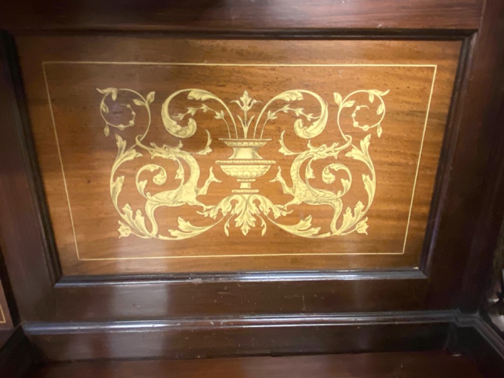 An Aesthetic Movement dark wood side cabinet featuring detailed marquetry inlays, an elevated superstructure with a central glazed cabinet, open niches, a mirror, a single drawer, and lower shelf spaces. View XII