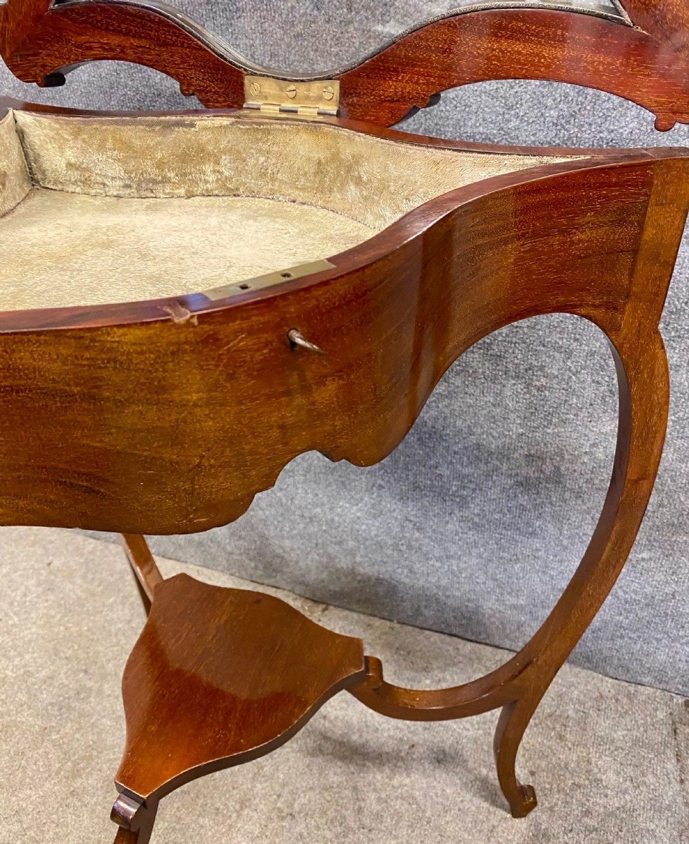 A three-sided serpentine bijouterie table crafted from polished warm brown wood featuring a glass display lid and cabriole legs. View IV