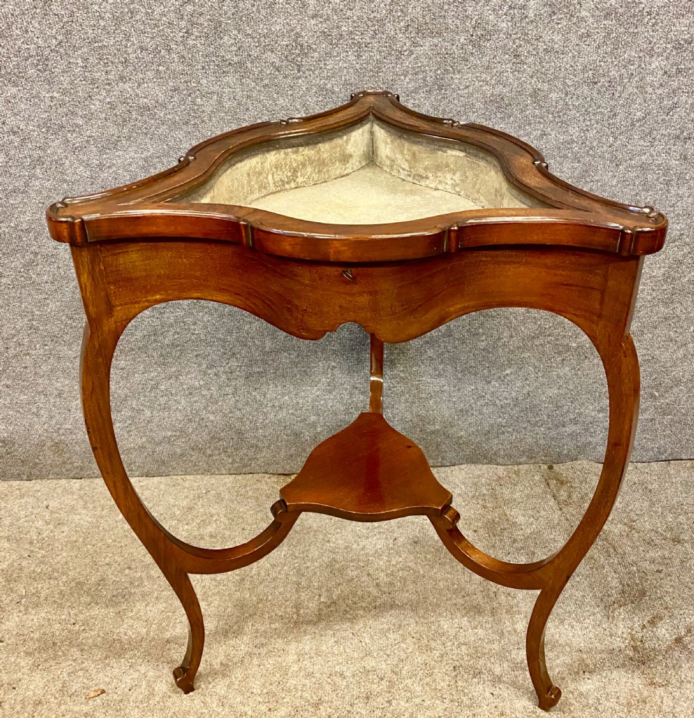 A three-sided serpentine bijouterie table crafted from polished warm brown wood featuring a glass display lid and cabriole legs. View V