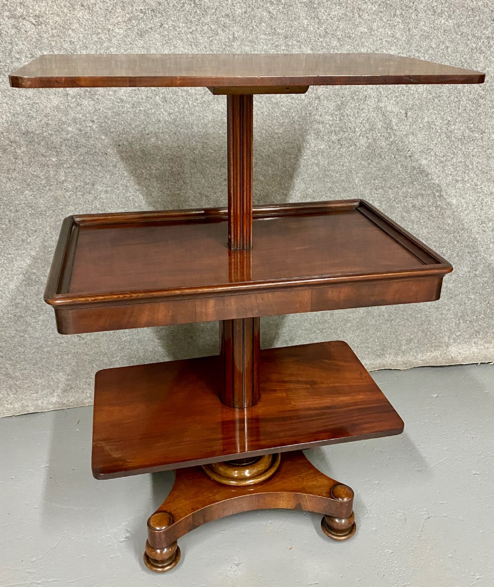 A three-tiered mahogany metamorphic dumb waiter table featuring fluted supports and a shaped quadform base. View III