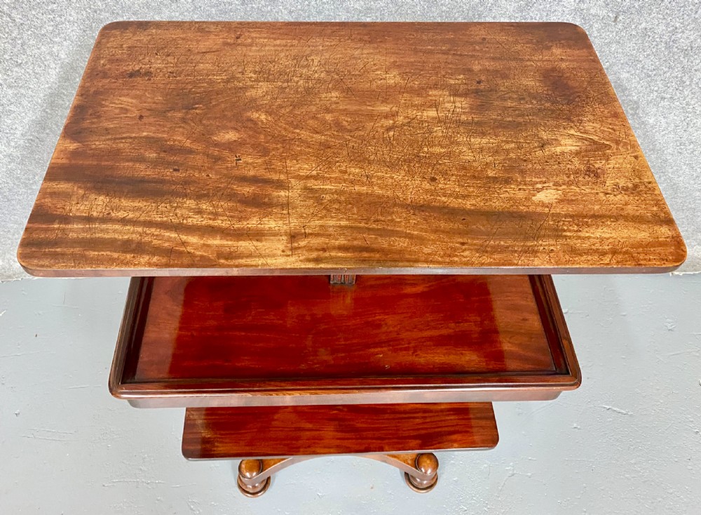 A three-tiered mahogany metamorphic dumb waiter table featuring fluted supports and a shaped quadform base. View IV