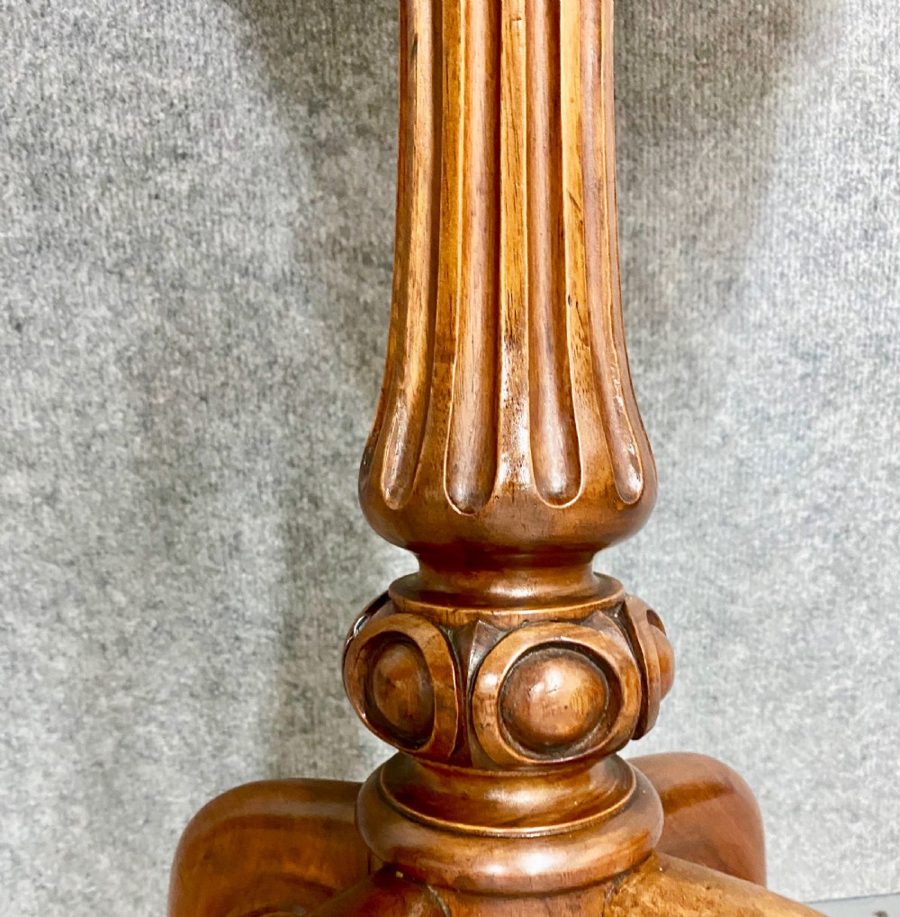 An antique Victorian burr walnut tea poy featuring gadrooned detail around the basin, a fluted central pedestal column, and carved scroll feet on castors. View VIII