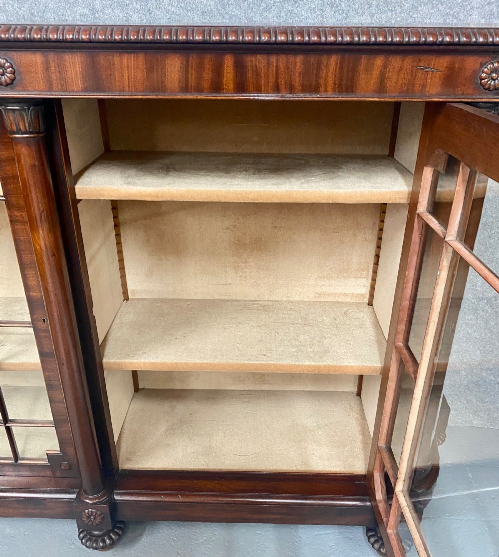 A nineteenth-century mahogany side cabinet featuring reeded columns, carved rosettes, gadrooned feet, and glazed doors. View XI