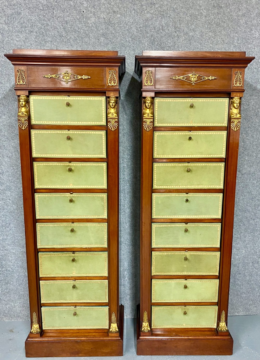 A pair of tall mahogany French Empire cartonnier chests featuring eight green gold-tooled leather drawers flanked by gilt ormolu mounts and terminal figures. View III