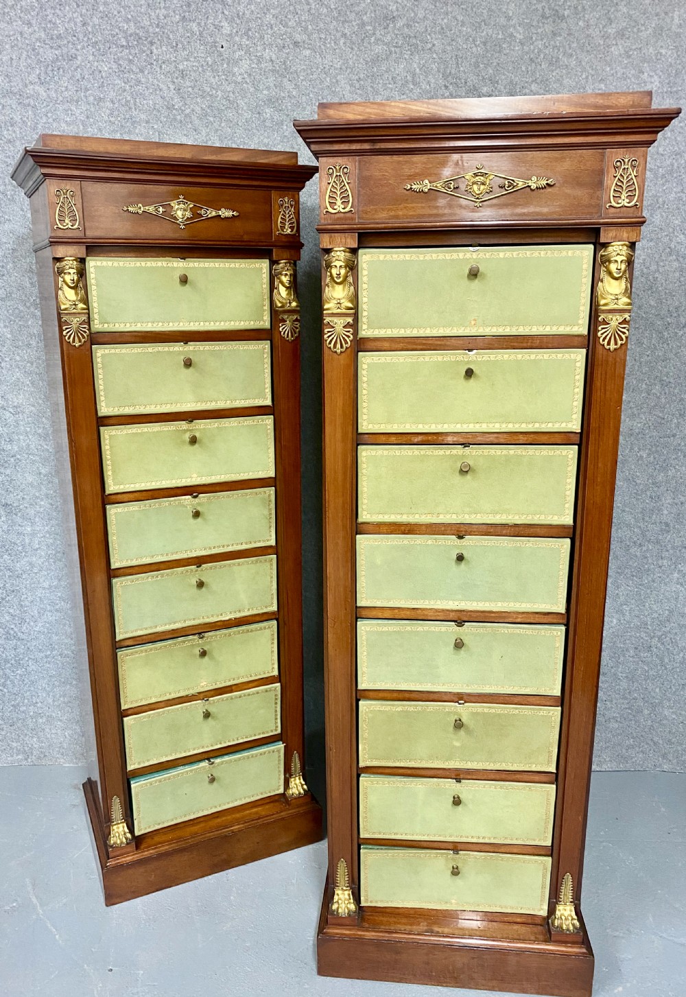 A pair of tall mahogany French Empire cartonnier chests featuring eight green gold-tooled leather drawers flanked by gilt ormolu mounts and terminal figures. View VII
