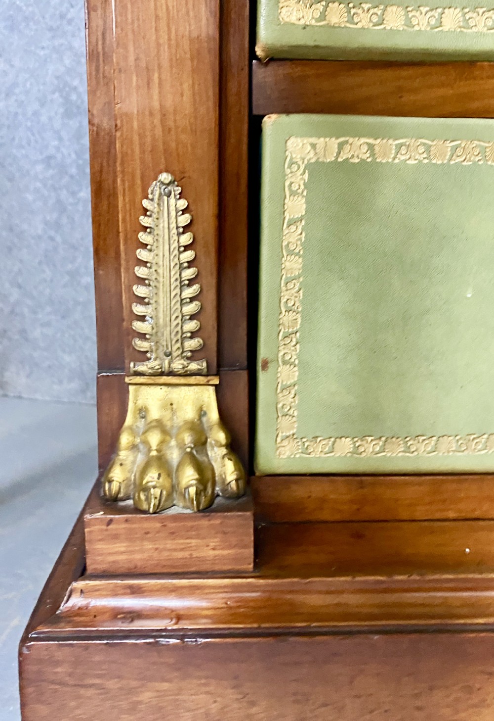 A pair of tall mahogany French Empire cartonnier chests featuring eight green gold-tooled leather drawers flanked by gilt ormolu mounts and terminal figures. View IX