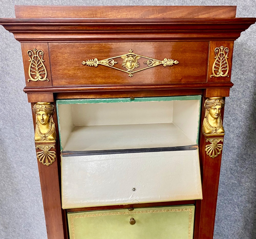 A pair of tall mahogany French Empire cartonnier chests featuring eight green gold-tooled leather drawers flanked by gilt ormolu mounts and terminal figures. View XIII