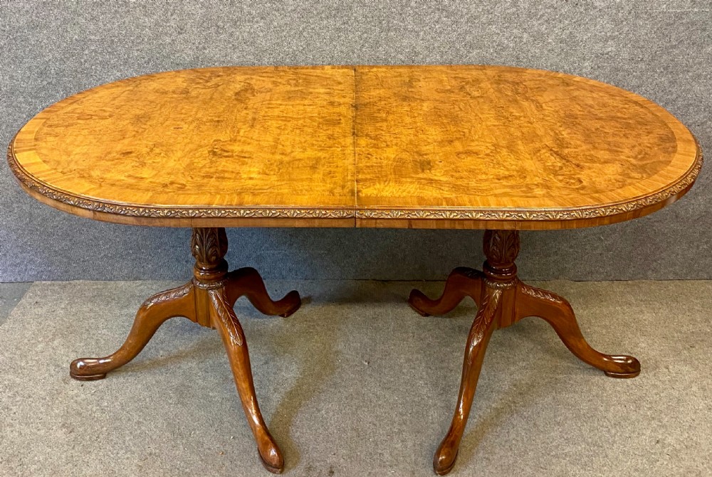 A nine-piece Queen Anne style dining room suite featuring a burr walnut dining table, matching sideboards, and red patterned fabric chairs with cabriole legs. View III